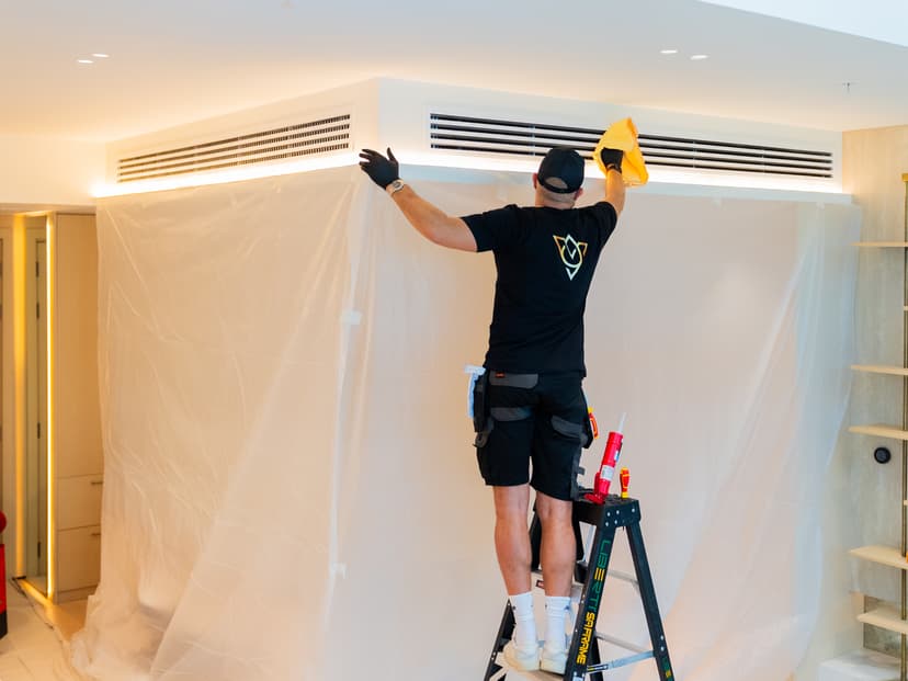 Engineer cleaning AC vent with cloth